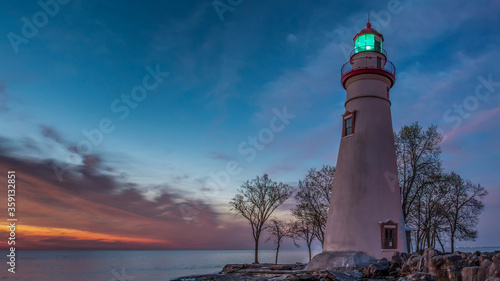 Marblehead Lighthouse at sunrise with beacon shining photo