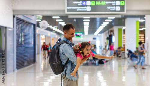 Little girl with her father background flight information at airport