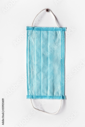 Medical mask hanging on the wall. Вisposable mask on a gray background. Medical disposable masks, Medical protective masks, Reusable mask, pneumonia