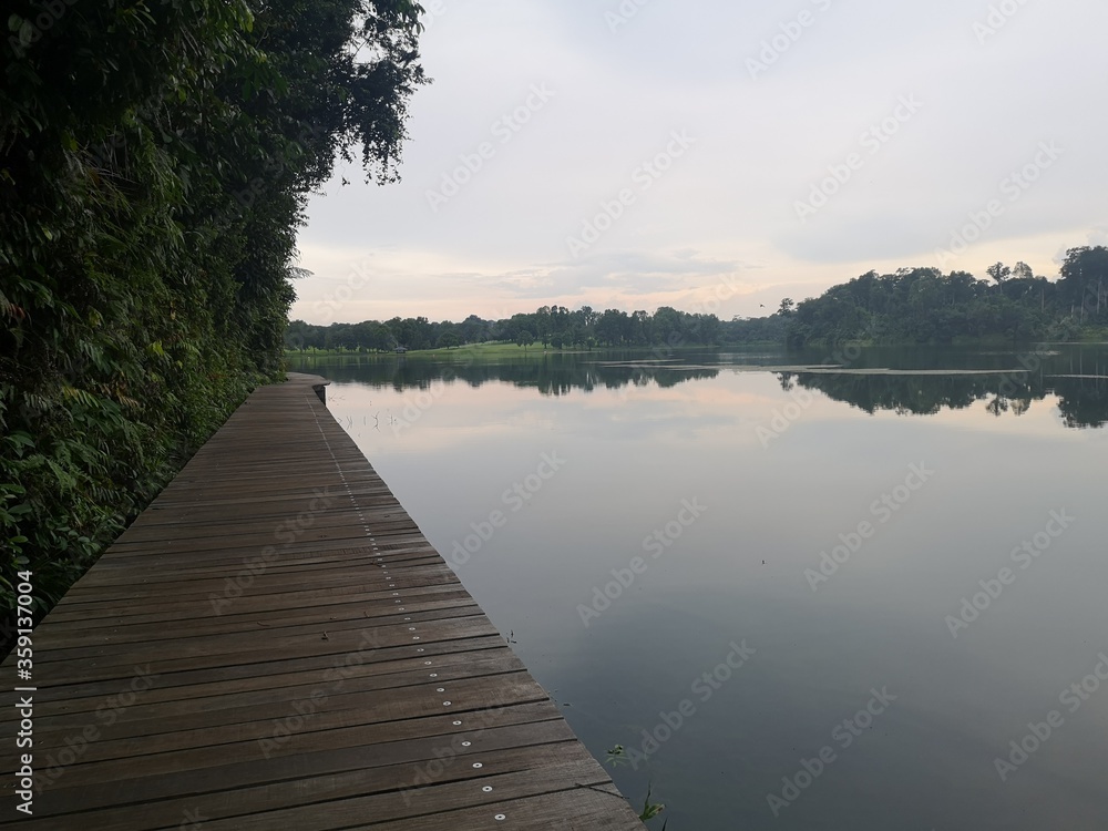 Fototapeta premium Wooden boardwalk trail close to water reservoir in Singapore 