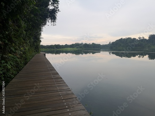 Wooden boardwalk trail close to water reservoir in Singapore 