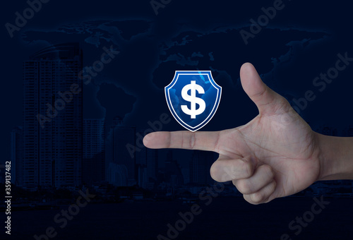 Hand pressing dollar with shield flat icon over world map, modern city tower and skyscraper, Business money insurance and protection online concept, Elements of this image furnished by NASA