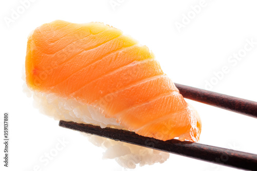 Traditional Asian food, premium delicacy and tasty oriental cuisine concept with close up picture on chopsticks that hold salmon (Japanese: sake) sushi on white background with clipping pat cutout