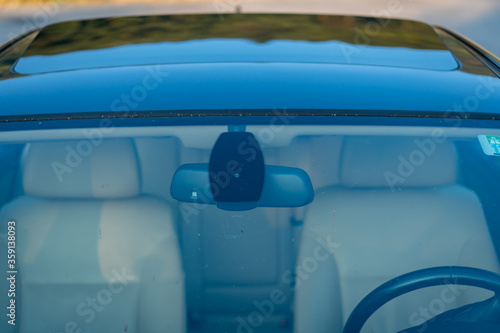 Windshield rain and light sensors position, luxury car windscreen, blue tinted glass, front view, technology design. Blue isolated glass  and dimming rear mirror