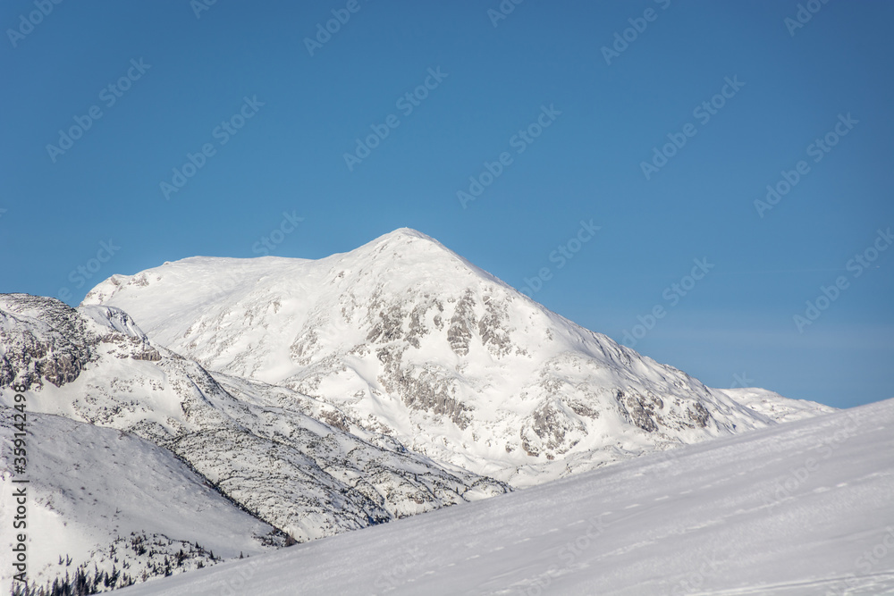 Alps mountains covered in snow. Winter season in highlands. Hiking on bright sunny day. Beautiful nature with sky without clouds