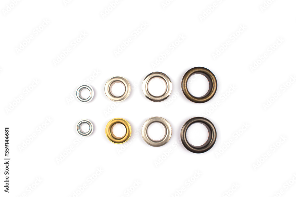 Set of brass multicoloured metal eyelets or rivets - curtains rings for fastening fabric to the cornice, isolated on white. With copyspace for text for your presentation Set of brass multicoloured metal eyelets or rivets - curtains rings for fastening fabric to the cornice, isolated on white. With copyspace for text for your presentation