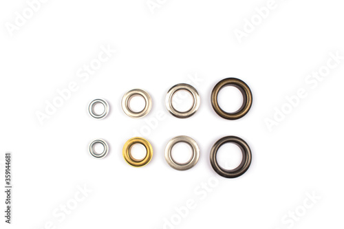 Foto Set of brass multicoloured metal eyelets or rivets - curtains rings for fastening fabric to the cornice, isolated on white