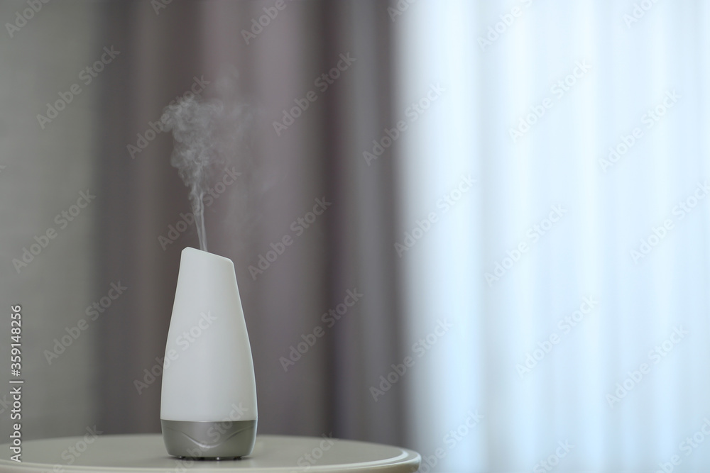 Aroma oil diffuser on table indoors. Space for text Aroma oil diffuser on table indoors. Space for text