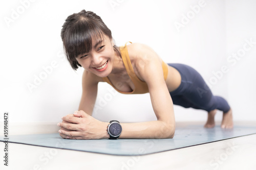 Slika na platnu Portrait of young sporty happy Asian woman warm up exercise planking on Yoga mat