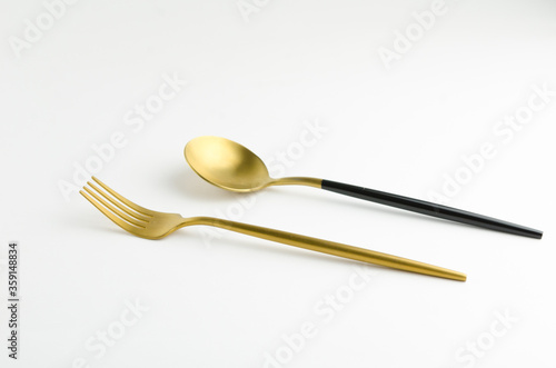 Golden spoon and fork in a tableware