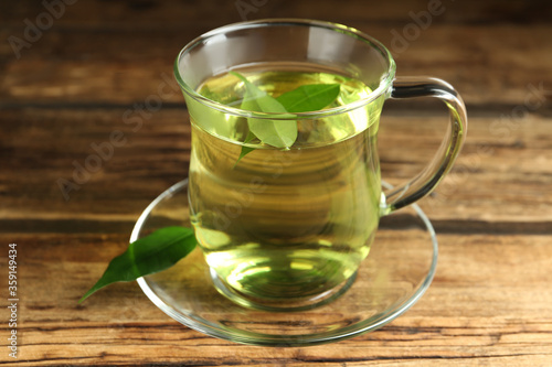 Cup of aromatic green tea on wooden table