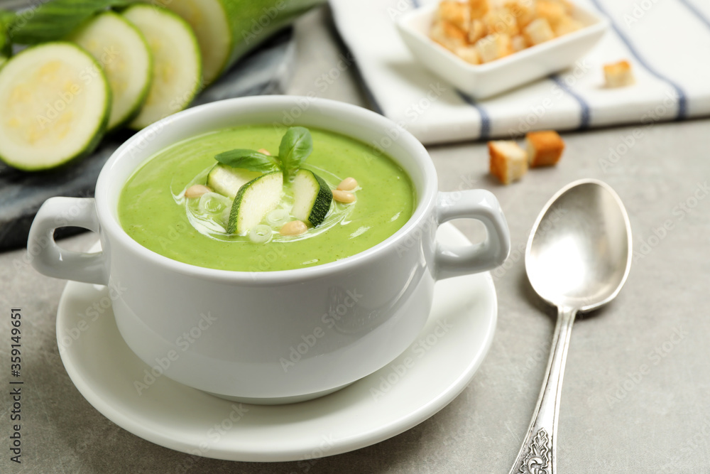 Tasty homemade zucchini cream soup served on grey table Tasty homemade zucchini cream soup served on grey table