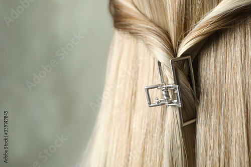 Young woman with beautiful hair claw on grey background, closeup