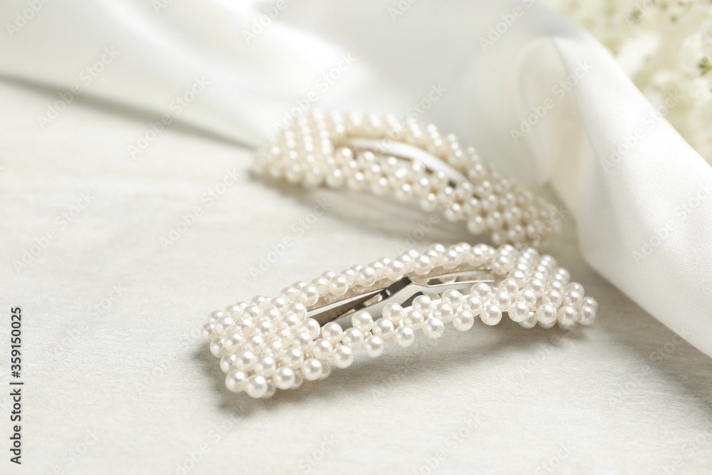 Fototapeta premium Beautiful hair clips with pearls on white table