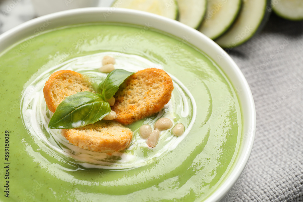 Tasty homemade zucchini cream soup in bowl on table, closeup Tasty homemade zucchini cream soup in bowl on table, closeup