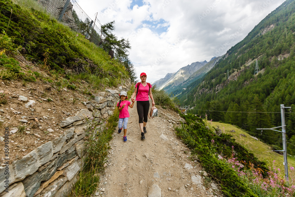 Hikers with backpack looking at mountains, alpine view, mother with child