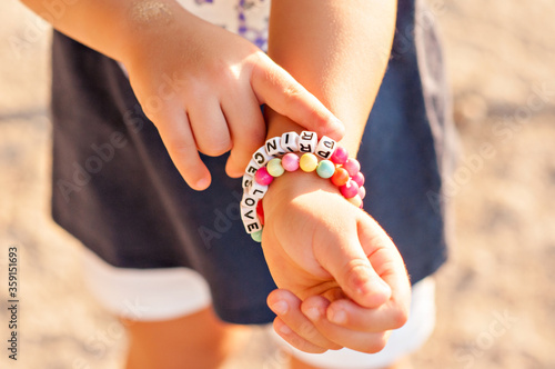 Fotografia, Obraz DIY bracelet for children from square, round, colored beads with the words Love and Princess