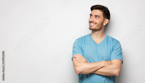 Banner of inspired man in blue t-shirt with crossed arms isolated on gray background