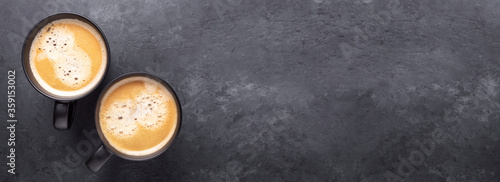 Banner. Cups with coffee on dark stone background. Top view. Copy space