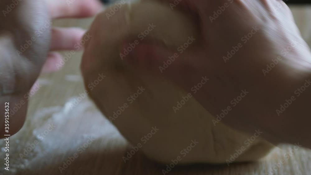 Female hands kneading dough in flour on the table, sunlight from the window illuminates the scene. Shallow depth of focus. Video taken close-up with natural light in 4k Female hands kneading dough in flour on the table, sunlight from the window illuminates the scene. Shallow depth of focus. Video taken close-up with natural light in 4k