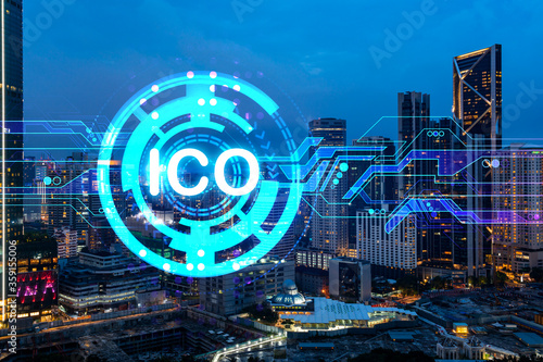 Initial coin offering hologram, night panorama city view of Kuala Lumpur. KL is the center of cryptocurrency projects in Malaysia, Asia. The concept of widespread ICO hysteria. Double exposure.