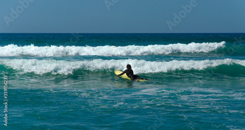 Surfer rides on a wave in the Atlantic ocean. Blue sky, banner. High quality photo