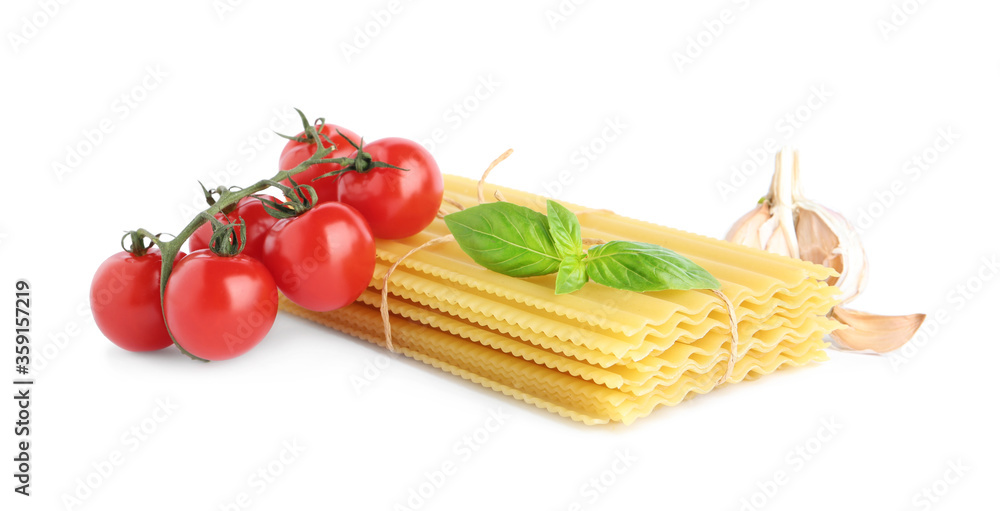 Uncooked lasagna sheets with cherry tomatoes, garlic and basil isolated on white Uncooked lasagna sheets with cherry tomatoes, garlic and basil isolated on white