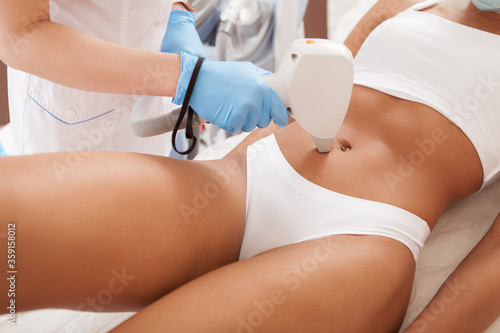 Unrecognizable African woman with fit body getting laser hair removal procedure at beauty clinic