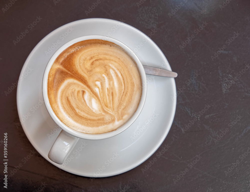Italian cappuccino coffee cup top view on dark wood table background, space for text Italian cappuccino coffee cup top view on dark wood table background, space for text