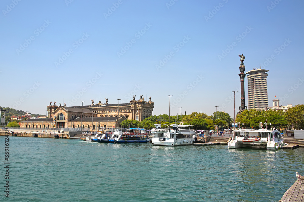 View across the harbour towards the city including the Columbus Monument, Aduana Building and the old customs building at Port Vell, Barcelona, Spain.