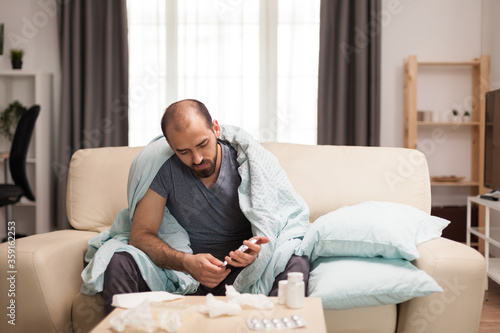 Sick man checking his pills during self isolation.