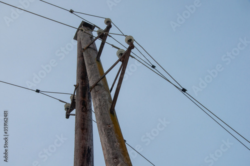 Energieversorung durch hölzernen Starkstrommasten mit Leitungsdrähten photo