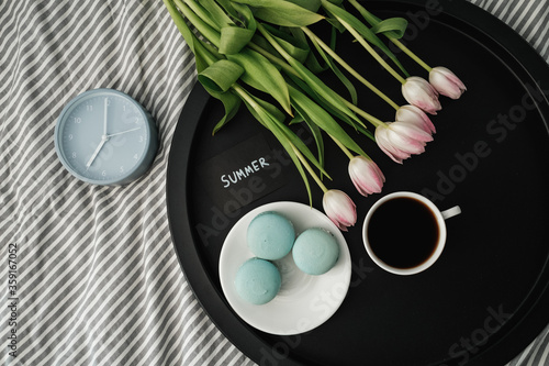 Top View of Note  Summer  on Tray with French Macarons and Fresh Tulips with Cup of Coffee and Alarm Clock
