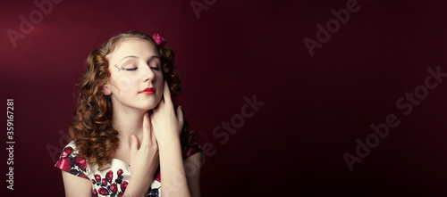 Portrait of a cute girl in pin-up style on red paper background. Stylish photography in vintage style.
