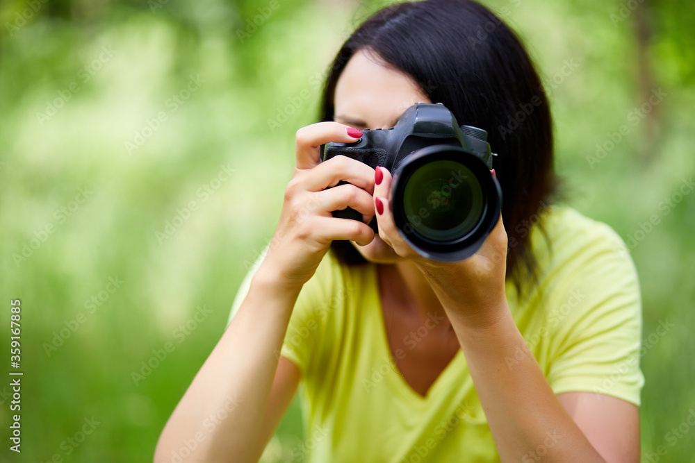 Portrait of a woman photographer covering her face with the camera Portrait of a woman photographer covering her face with the camera
