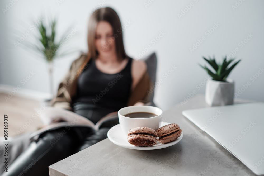 Young Adult Girl Reads a Magazine Sitting on Sofa Young Adult Girl Reads a Magazine Sitting on Sofa