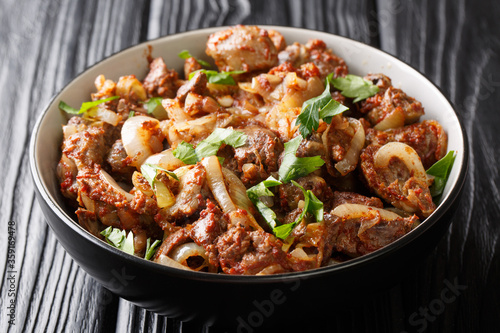 Armenian cuisine recipe chicken liver, heart and stomachs with onions, tomatoes and spices close-up in a bowl on the table. horizontal © FomaA