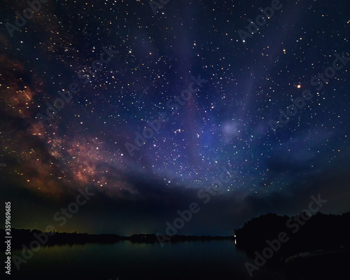 landscape with a starry sky on a river on a summer night