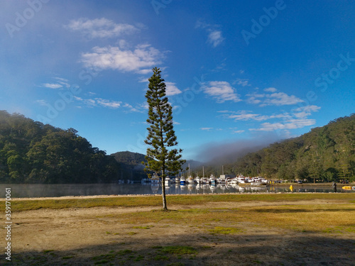 Beautiful morning view of Cowan creek with reflections of blue sky, boats, mountains and trees, Bobbin Head, Ku-ring-gai Chase National Park, New South Wales, Australia photo