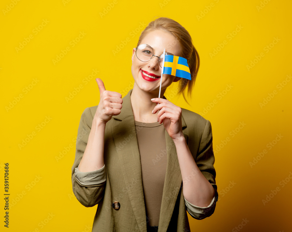 Style blonde woman in jacket with Swedish flag on yellow background Style blonde woman in jacket with Swedish flag on yellow background