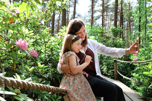 Obraz na płótnie Mother and her daughter take a selfie in Rhododendrons Park. It is one of the most popular and beautiful places in Helsinki, Finland. w salonie