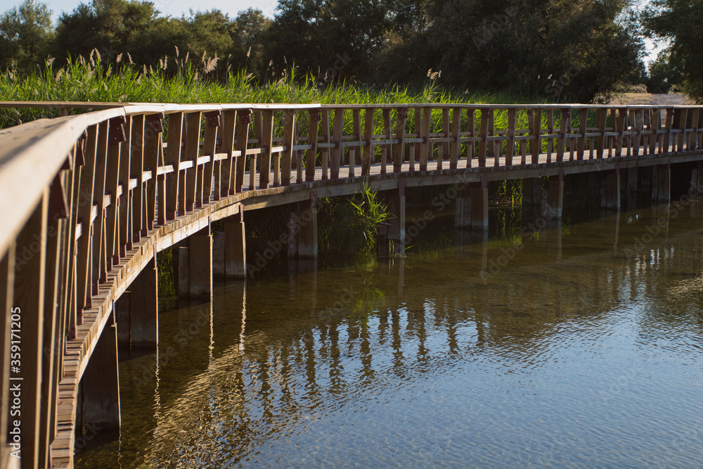 Wooden footbridge over a river. Tablas de Daimiel. Spain Wooden footbridge over a river. Tablas de Daimiel. Spain