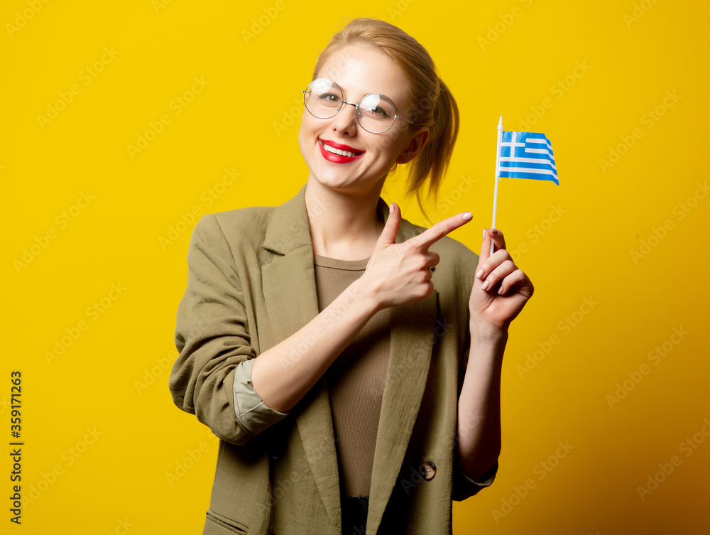 Style blonde woman in jacket with Greek flag on yellow background Style blonde woman in jacket with Greek flag on yellow background