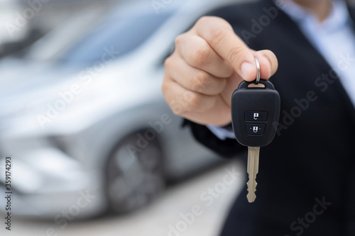 The staff holds the new car keys and offers special interest promotions to customers at the showroom. © kamonwan