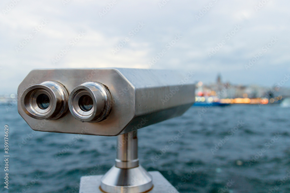 Tourist telescope against blurred sea background. Binoculars for sightseeing. Tourist telescope against blurred sea background. Binoculars for sightseeing.