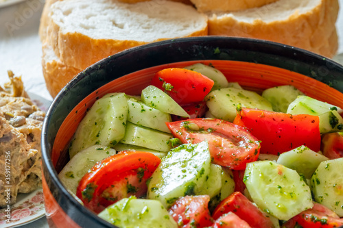 Tomato and cucumber salad with onion, pepper and parsly photo