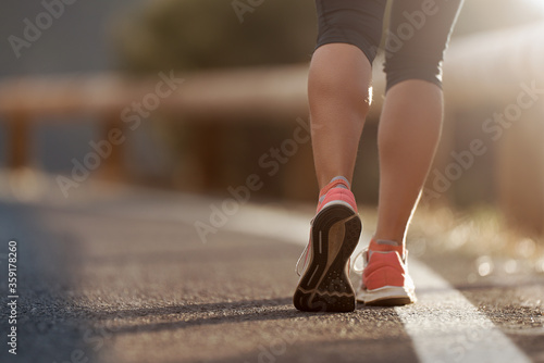 Running shoe closeup of woman running on road with sports shoes