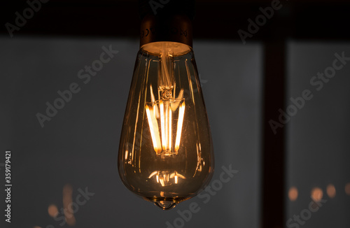 Set of vintage glowing light bulbs on dark background. Many different vintage light bulbs hanging from ceiling. close-up ampoule