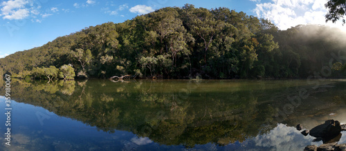 Beautiful morning panoramic view of Apple Tree Creek with reflection of blue sky, mountains and trees, Ku-ring-gai Chase National Park, New South Wales, Australia photo