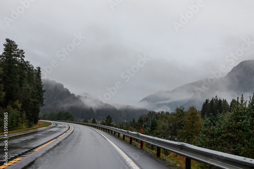 Highway road in a misty mountains of Norway. Autumn picturesque fog low clouds on way to Oslo on a rainy wet morning